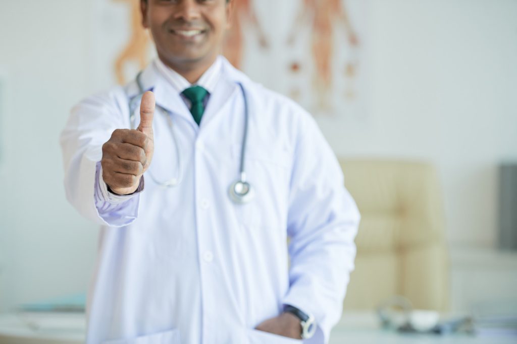 médico com polegar para cima indicando eficiência das campanhas de saúde em empresas